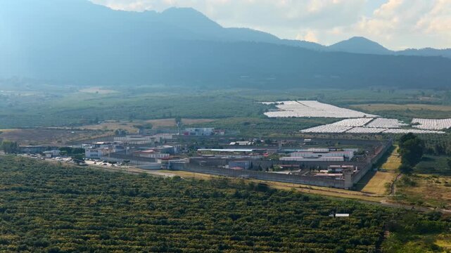 Dolly in aerial toward PGR penal complex surrounded by farmland and mountains, Ciudad Guzman Jalisco Mexico.