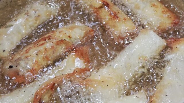Deep-frying spring rolls to crispy perfection.
