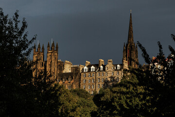 Obraz premium Dark gothic church spire and historic stone buildings in Scotland