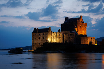 Eilean Donan Castle illuminated at twilight on a loch in the Scottish Highlands