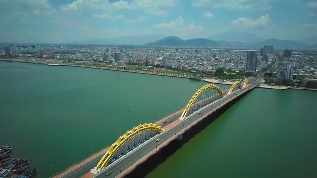 Drone flying alongside the iconic dragon bridge over the han river in da nang, vietnam