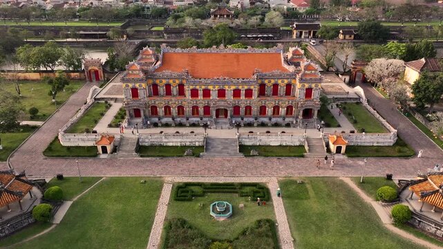 Kien Trung Palace in Hue Imperial City with a vibrant yellow facade, red shutters and roof details. Aerial Drone Shot