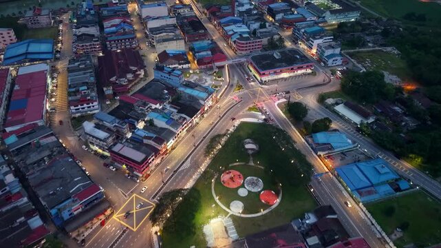 Drone panorama reveals Kota Tinggi night traffic with clustered lights, moving vehicles, and expansive townscape.