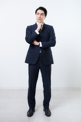 立つハンサムな中堅ビジネスマン全身　考える悩む