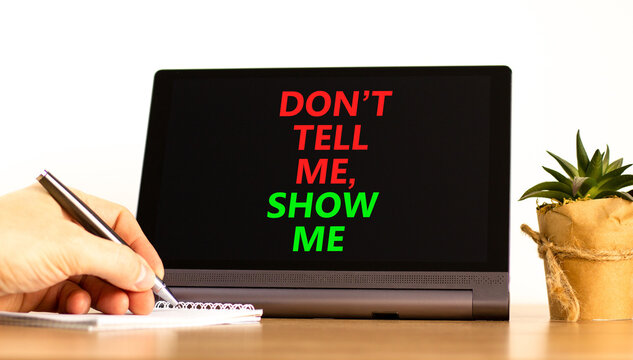 Tell or show symbol. Concept words Do not tell me, show me on beautiful black tablet's screen. Beautiful white background. Businessman's hand. Business tell or show concept. Copy space.