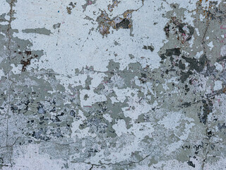 Vintage wall texture. Rough surface of the plastered concrete wall of the building. A pattern with many cracks and old faded peeling paint. Perfect for background and design. Closeup.