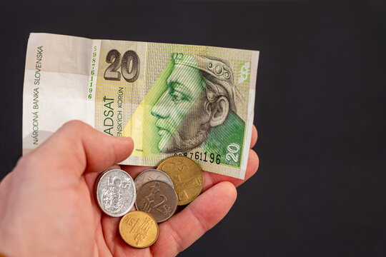 20 Slovak koruna banknote with Slovak coins held in hand before euro adoption. Former currency of Slovakia used until 2009. Close up on dark background.