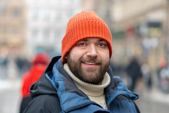 35 year old man on a city street among pedestrians in winter day.