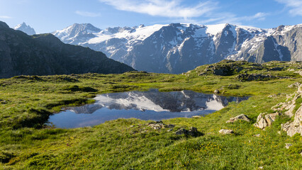 reflet des glaciers de la Meije sur un lac du plateau d'Emparis au refuge des Mouterres dans les Alpes en &eacute;t&eacute;