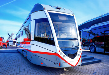 New modern tram stands at exhibition in city. A modern low-floor tram is parked at exhibition. Tram has sleek design and is ready for passengers. © MaxSafaniuk