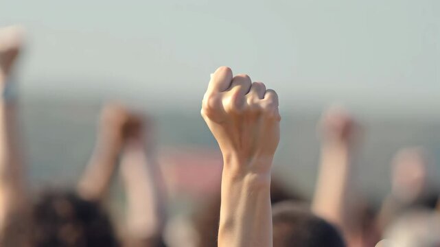 Raised fists of protesters at demonstration, symbol of solidarity, freedom and social justice concept.