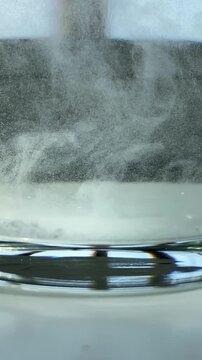 Impurities in water. Particles in water.Epsom salt. Salt. Glass. Glass of water. Epsom salt. Slow motion video. High quality 4k footage