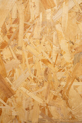 Textured wooden OSB background with natural timber flakes, recycled materials for eco-friendly furniture and interior design. Solid chipboard pattern suitable for professional and creative projects.