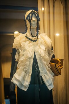 Milan, Italy - 2026, 17 Feb: DAAD SS26 collection features a dramatic ruffled blouse, gold clutch, and avant-garde headpiece in a striking fashion window display