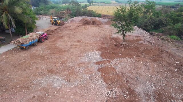 High angle aerial drone view of a heavy duty hydraulic earth excavator operating at a construction site near Pune India.