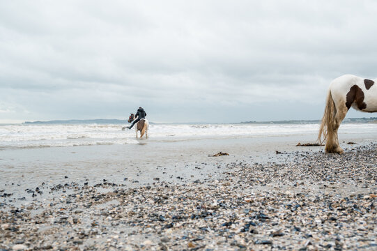 Man on a horse in the waves on Donabate beach in Dublin, Ireland