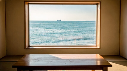 和室の大きな窓から眺める穏やかな青い海と、水平線をゆく船。静寂と開放感に包まれた、日本情緒溢れるオーシャンビューの景色。