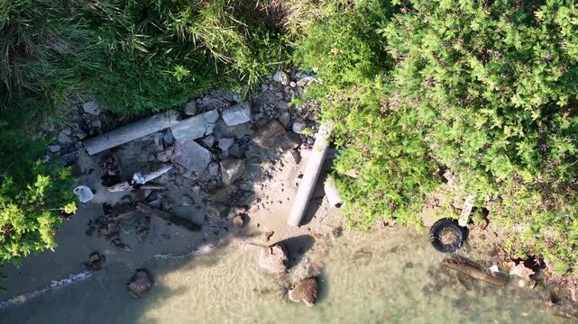 Aerial coastal water pollution shoreline debris and pipes