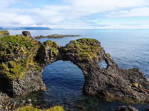 Gatklettur - cliff with circular rock arch on the coast of Atlantic ocean in west of Iceland, Sn&aelig;fellsnes Peninsula. Coastal trail from Hellnar to Arnarstapi fishing village, with lava rock formations