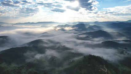 Naklejka premium Aerial view of mountains and forest with the sea of fog before sunrise by drone