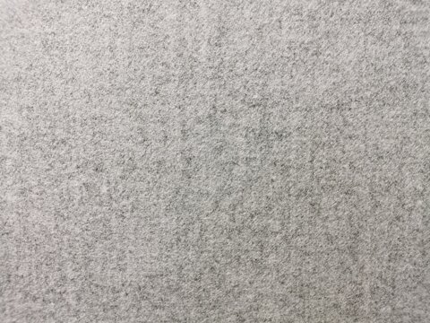 High-quality close-up of a seamless grey felt texture with a soft, heathered finish. The dense, non-woven fibrous surface creates a clean, neutral background perfect for minimalist design, industrial 