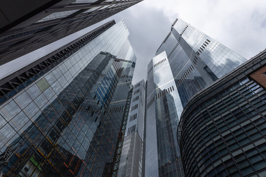 Modern glass skyscrapers reaching towards a cloudy sky