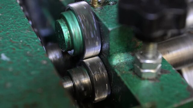 Rotating gears of the mechanism of an industrial machine. A machine for applying glue to sheets in the production workshop of the printing house