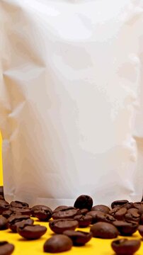 White stand-up pouch packaging with coffee beans on yellow background