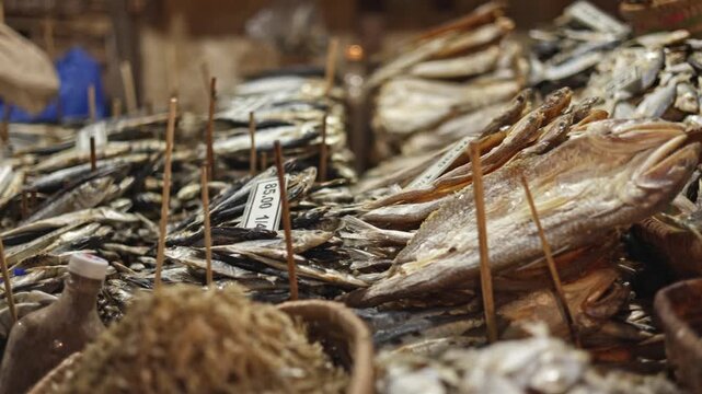 Dried fish sale with seller weighing on market scales stall, dried fish sale shows fresh row with vibrant basket variety, healthy scene, sale moment, designed for street vendor transaction content.