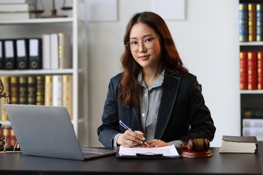 Asian female lawyer reviewing legal documents, providing legal advice and counsel to clients.