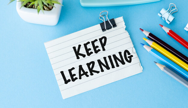 Keep Learning motivational quote on paper note at office desk