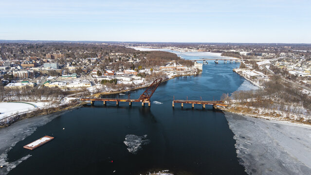 Aerial view of the Seekonk River with the open Crook Point Bascule Bridge cutting through the icy waters under a clear blue sky, Providence, Rhode Island, United States.