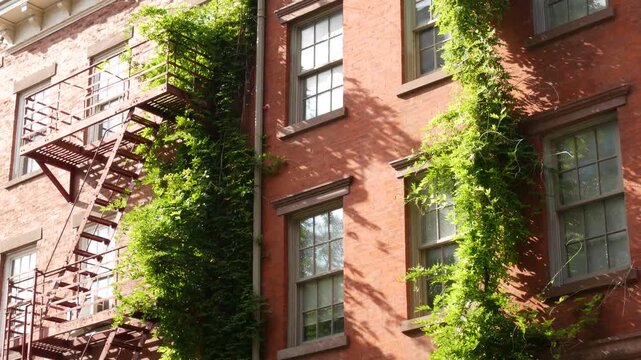 New York City urban residential buildings architecture, Manhattan classic street, United States of America. Typical red brick house in NYC, real estate property in USA. Fire escape metallic ladder.