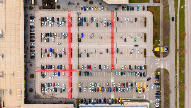 Aerial view of a meticulously organized parking lot, marked with bold red lines, filled with a colorful array of cars, Sremska Mitrovica, Vojvodina, Serbia.