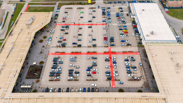 Aerial view of neat rows of cars fill the parking lot, contrasting with the red lines and expansive rooftops of the buildings, Sremska Mitrovica, Vojvodina, Serbia.