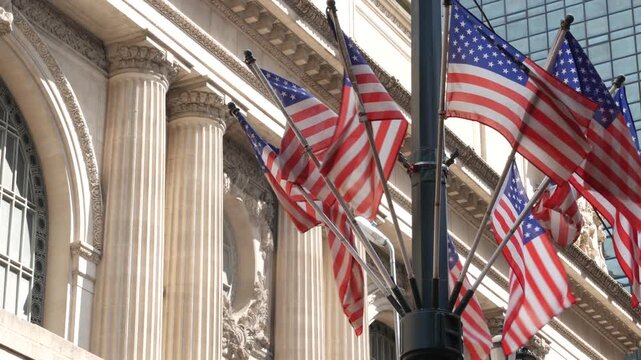 American flags near Grand Central Terminal on 42 street, New York City, Manhattan Midtown. Railway building architecture in United States. Public railroad transport junction. Old station exterior.