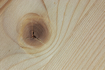 Large cracks formed in a knot on a wood surface