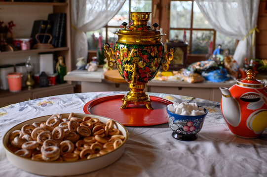 Traditional Russian samovar in Gzhel style on festive table with sugar cubes and baranki, authentic folk culture, Maslenitsa celebration and cozy national holiday concept