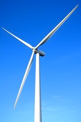 Fototapeta premium White wind turbine against clear blue sky energy power