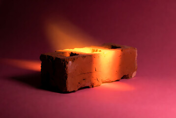 Brick glowing with bright orange light and warm glow effect on red background featuring clay, texture, rough with industrial and construction elements for material, building projects, clean