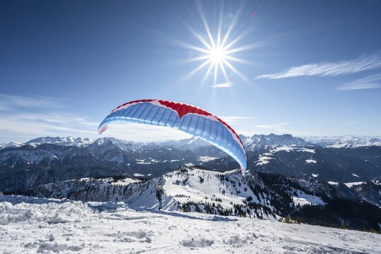 Paraglider at take-off in winter, summit of Sonntagshorn, mountain panorama, Sonnenstern, Chiemgau Alps, Bavaria, Germany