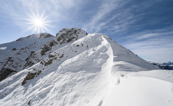 Snow cornices at an embrasure, Roggentalsattel, hiking trail to Ammergauer Hochplatte, sun star, in autumn, Ammergau Alps, Bavaria, Germany