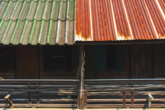 Old traditional wooden house balcony featuring unique sunburst wood carving decoration and designed to prevent people from climbing over balcony. Sunburst design by wood craft. Traditional lifestyle