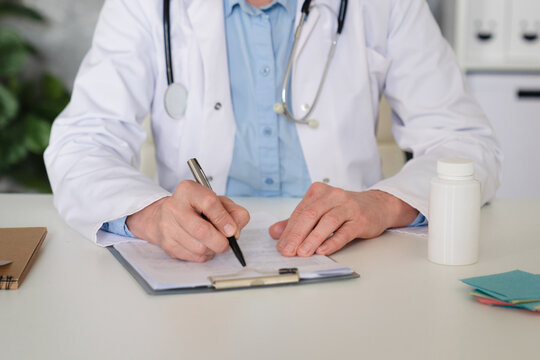 Woman, hands and doctor writing in book for prescription, medical history or reminder at office. Female person, healthcare worker or taking notes with diary for health record or diagnosis at clinic