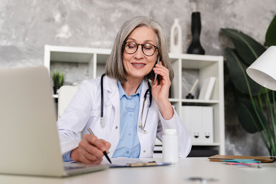 Woman, phone and doctor writing in book for prescription, medical history or reminder at office. Female person, healthcare worker or taking notes with diary for health record or diagnosis at clinic