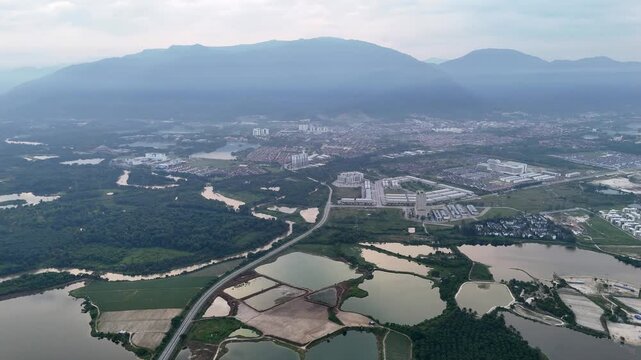 Drone view captures Kampar abandoned tin mines with shimmering water and green forest edges.