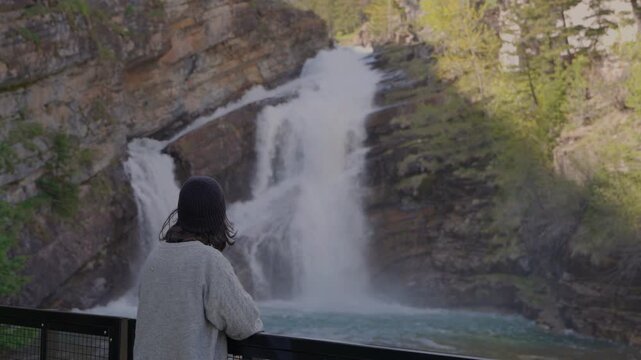 Woman enjoys the scenic beauty of Cameron Falls in Waterton Lakes National Park