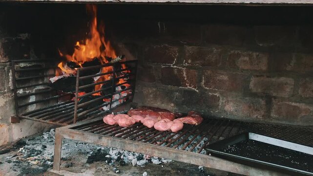 Fire Burning Under the Grill &ndash; Traditional Argentine Asado with Beef and Sausages