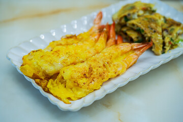 사각 접시에 담긴 노릇한 새우 튀김과 부침요리 