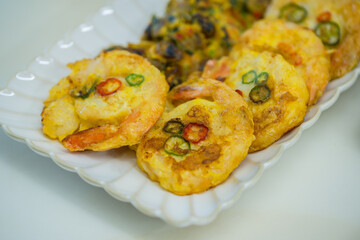 사각접시에 담긴 동그란 새우튀김과 부침요리